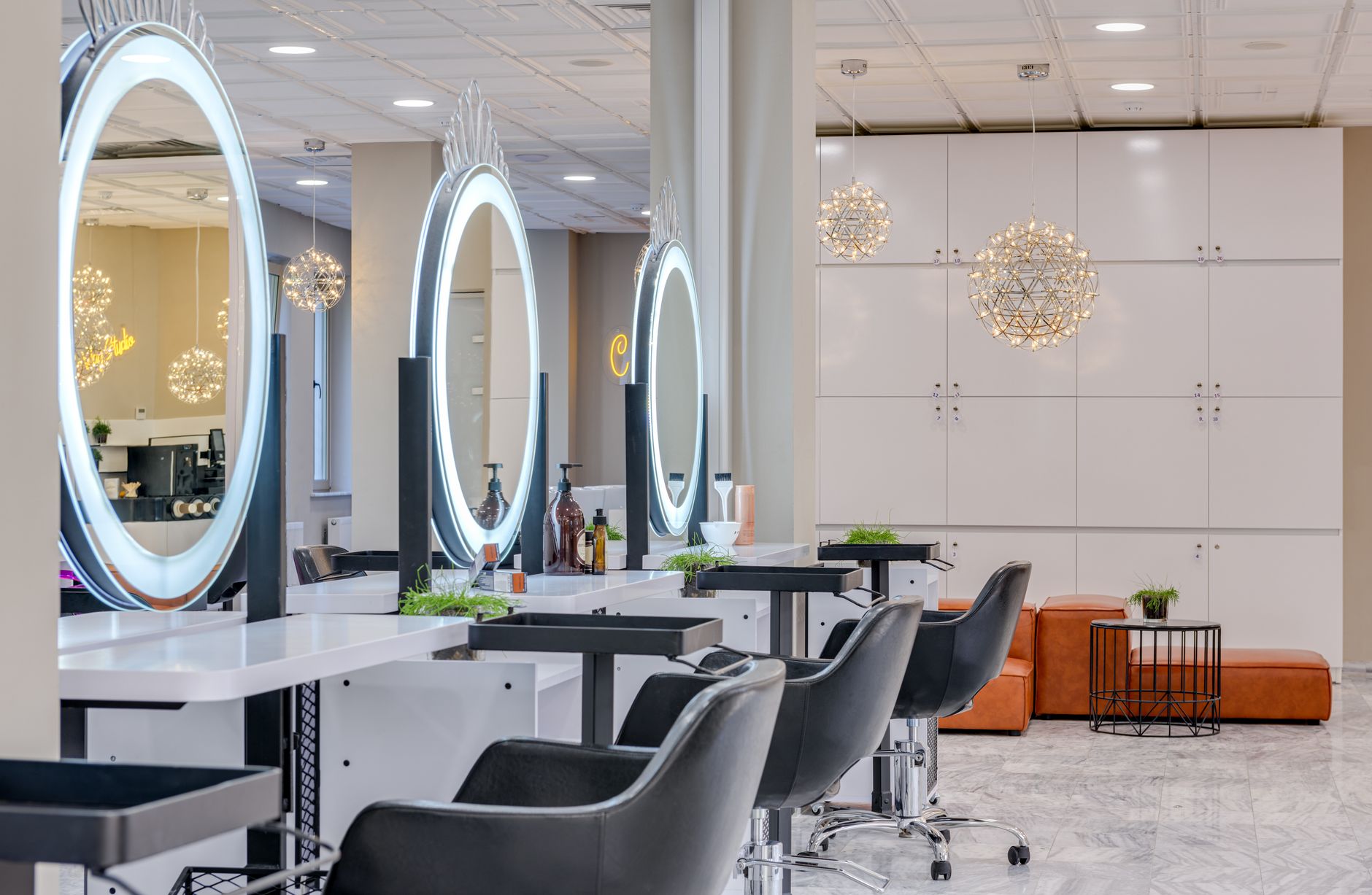 Detailansicht eines elegant eingerichteten Friseursalons mit Ledersesseln und runden Spiegeln